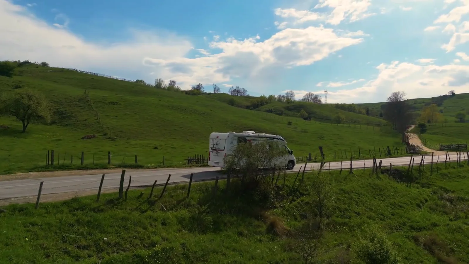 Autorulotă ATYC pe un drum printre dealuri verzi